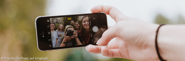 Jugendliche machen ein Selfie mit dem Smartphone